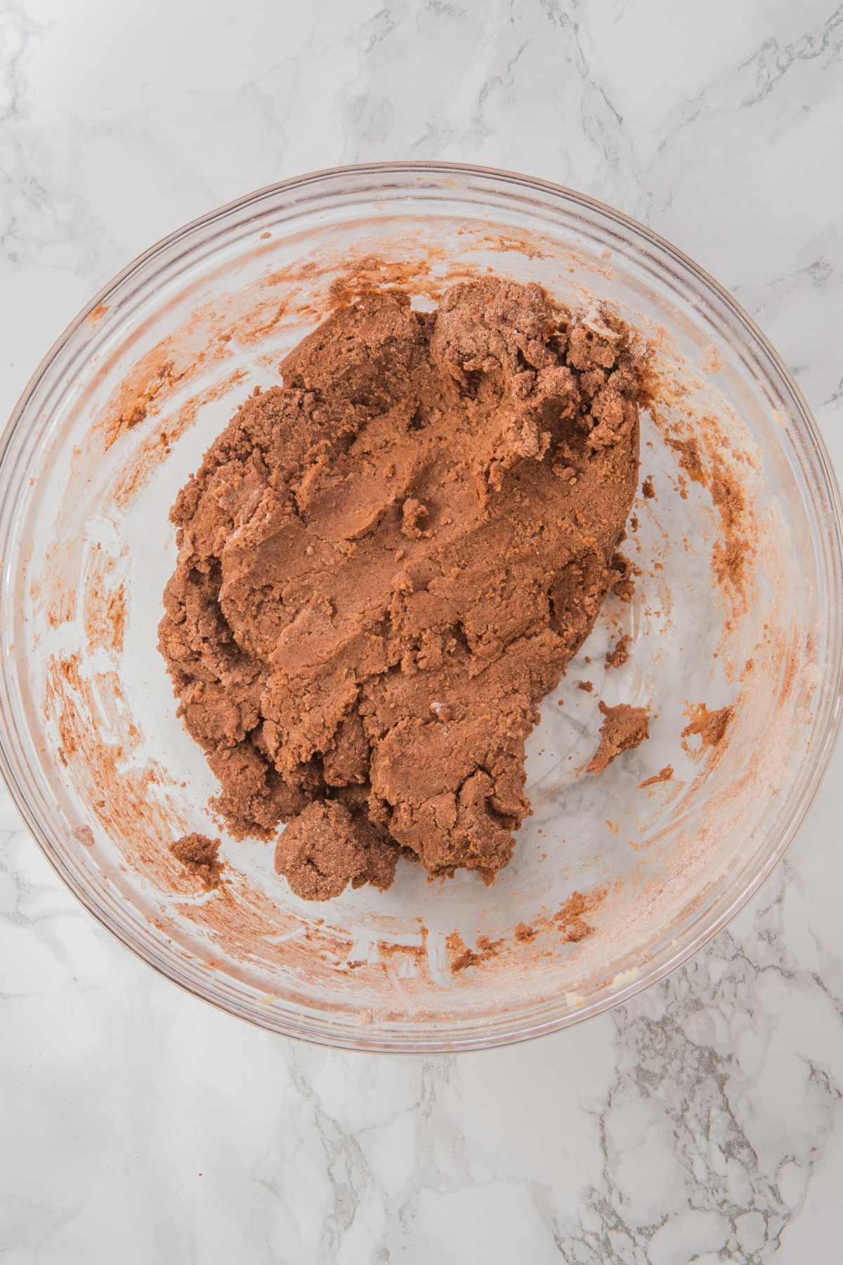 Chocolate sugar cookie dough in a mixing bowl before refrigerating.