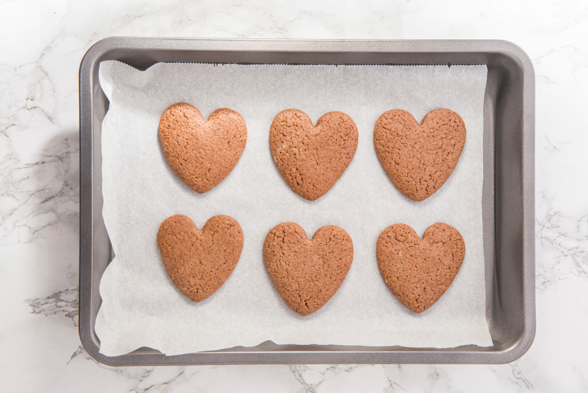 Baked heart cookies on a baking sheet.