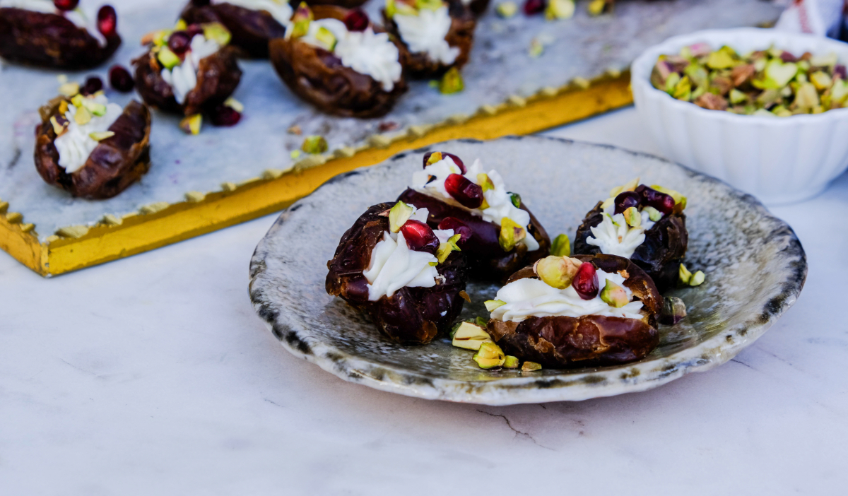 Cheese stuffed dates on a small cream serving dish.