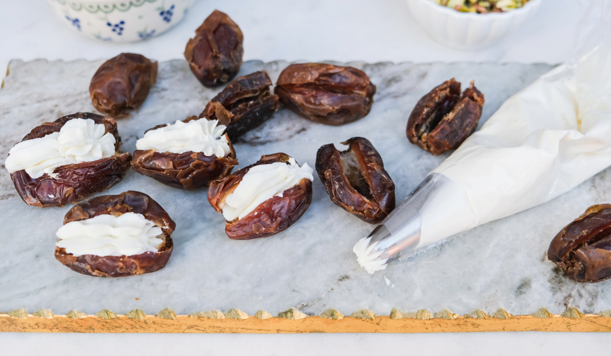 A piping bag with goat cheese and dates on the side to be filled.
