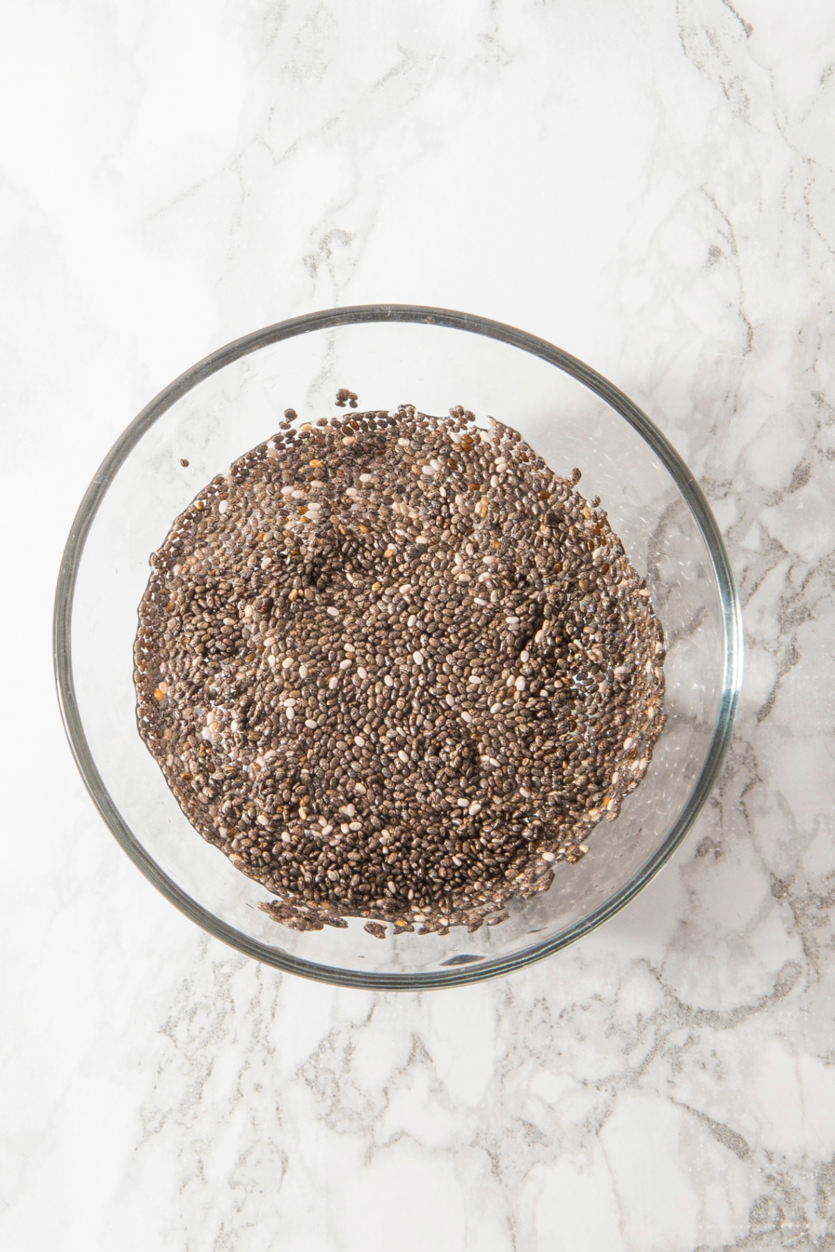 Chia seeds in a small mixing bowl with water forming a gel-like mixture.