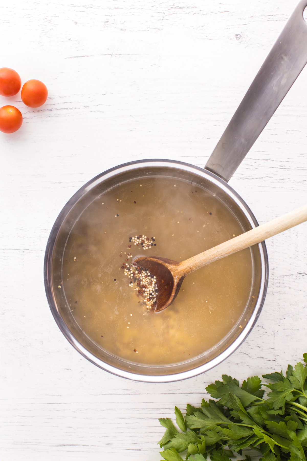 Quinoa cooking in vegetable broth in a saucepan.