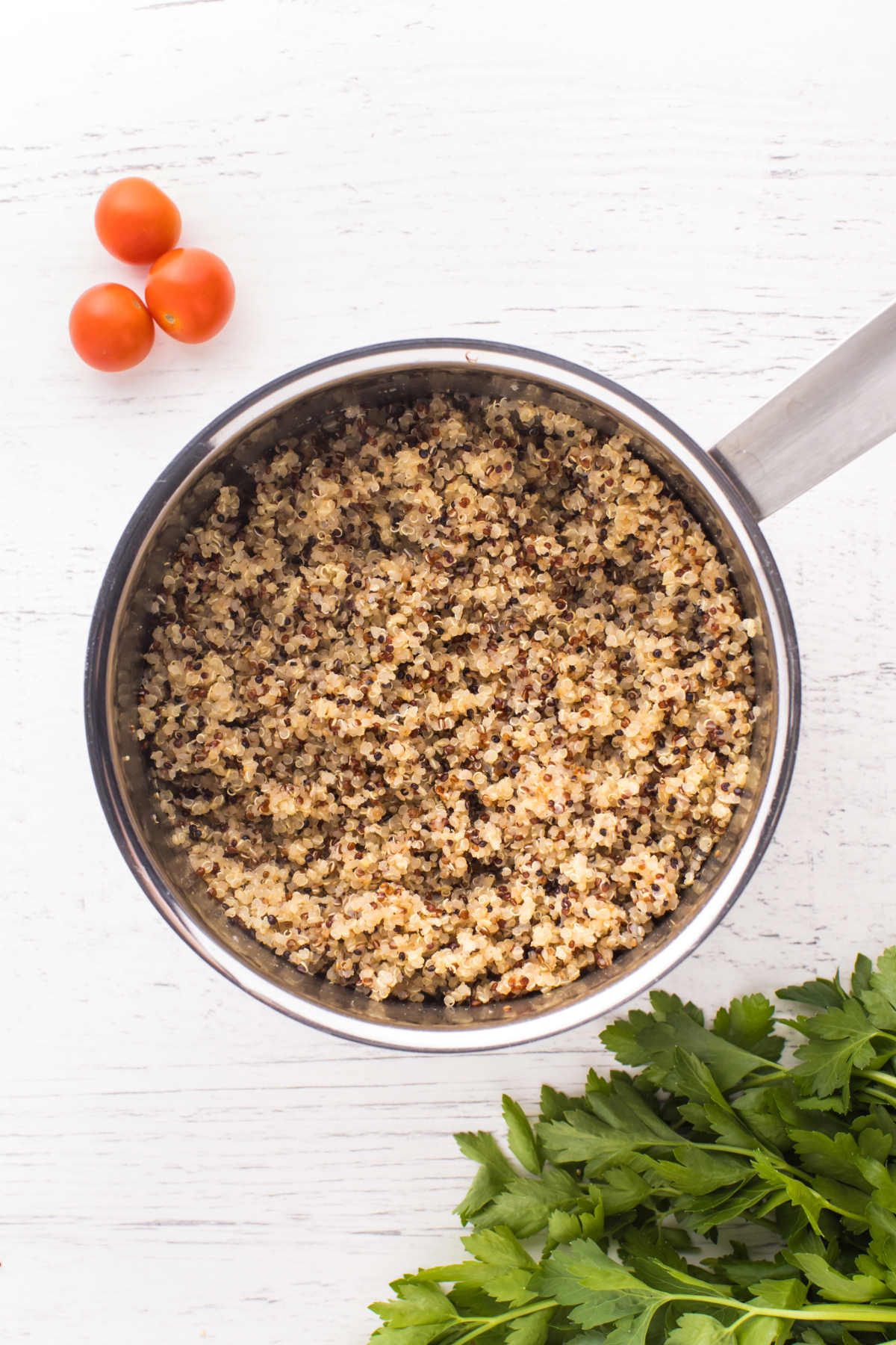 Cooked quinoa in a stainless steel saucepan.