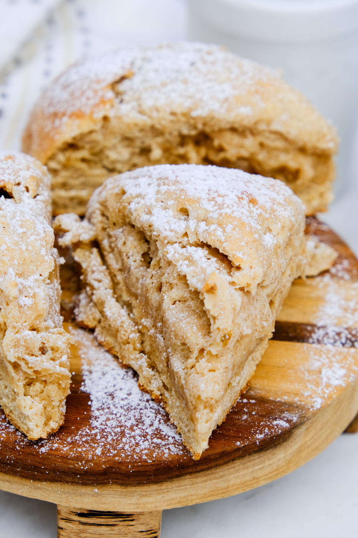 A fresh baked banana scone cut into triangles on a serving plate.