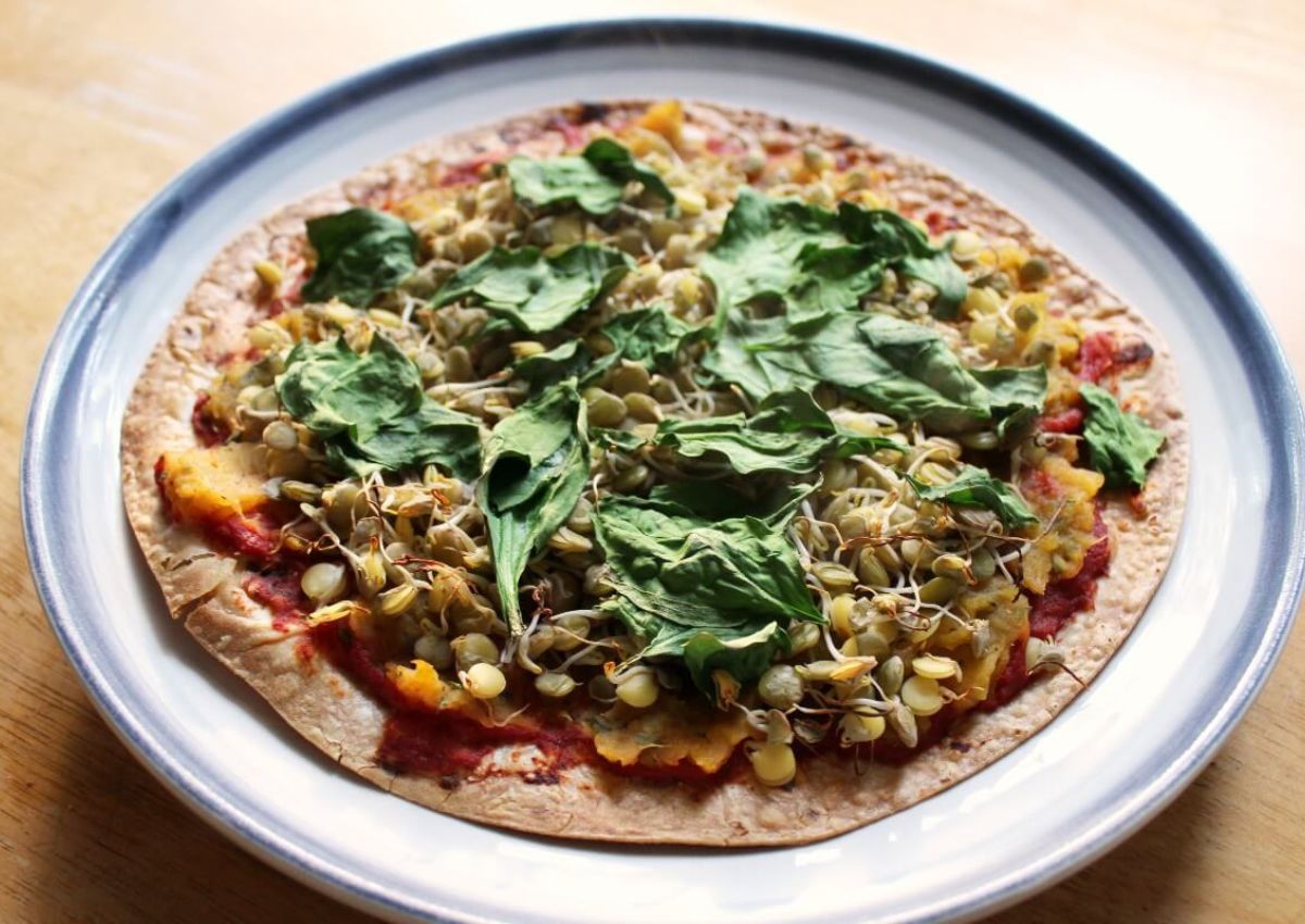 Butternut squash pizza on a blue and white plate.