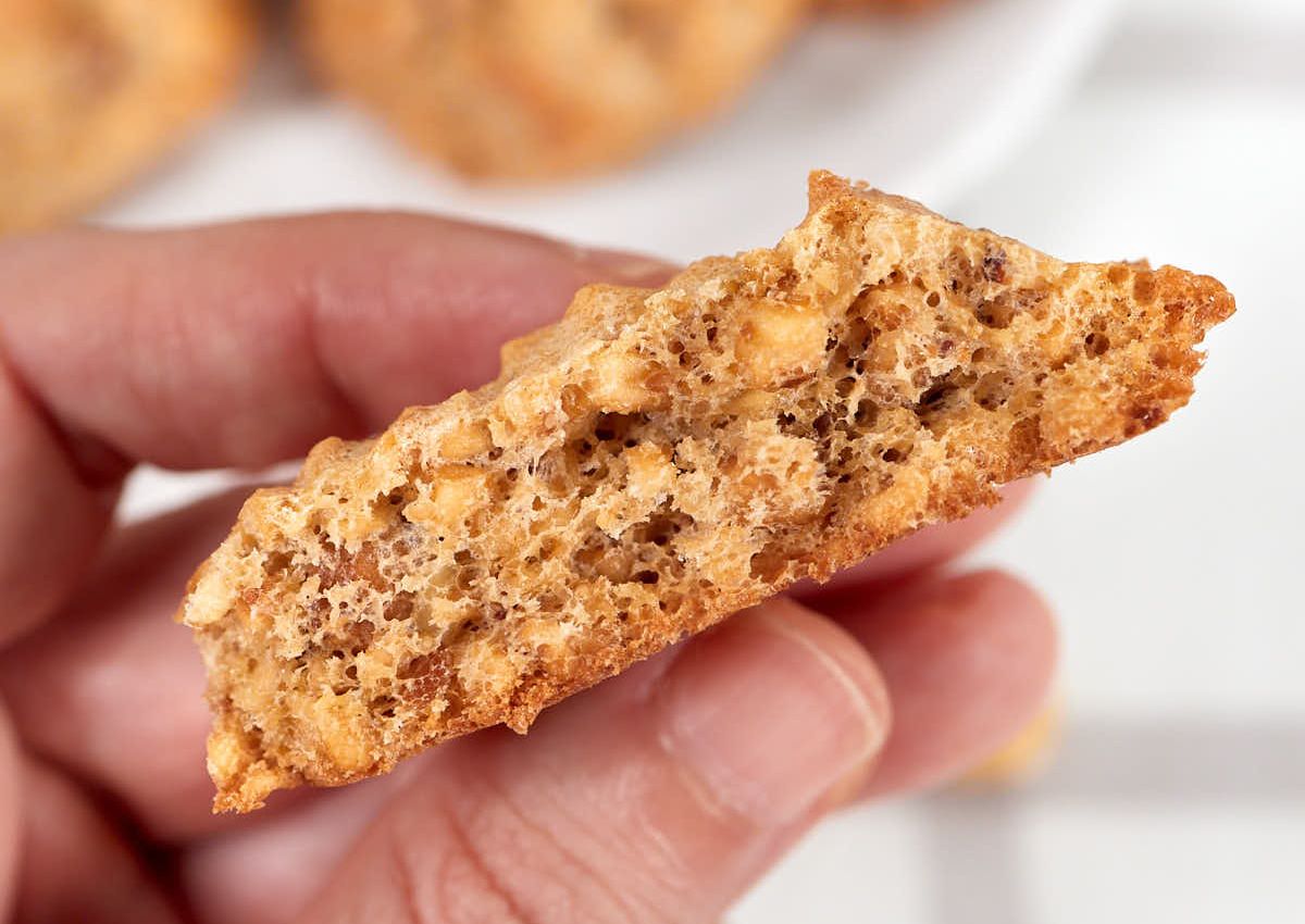 Keto hazelnut cookie held in a woman's hand.