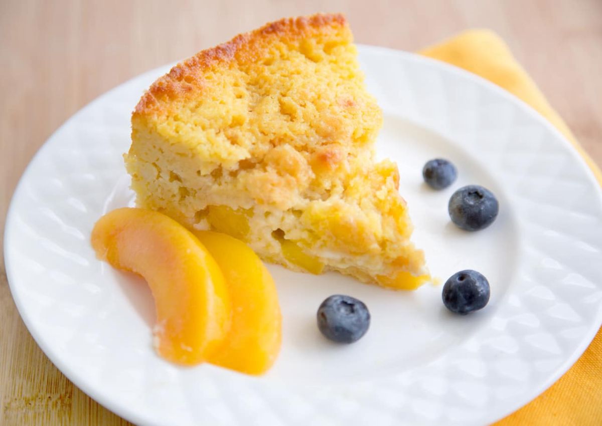 Slice of peach and cream breakfast cake on a plate.