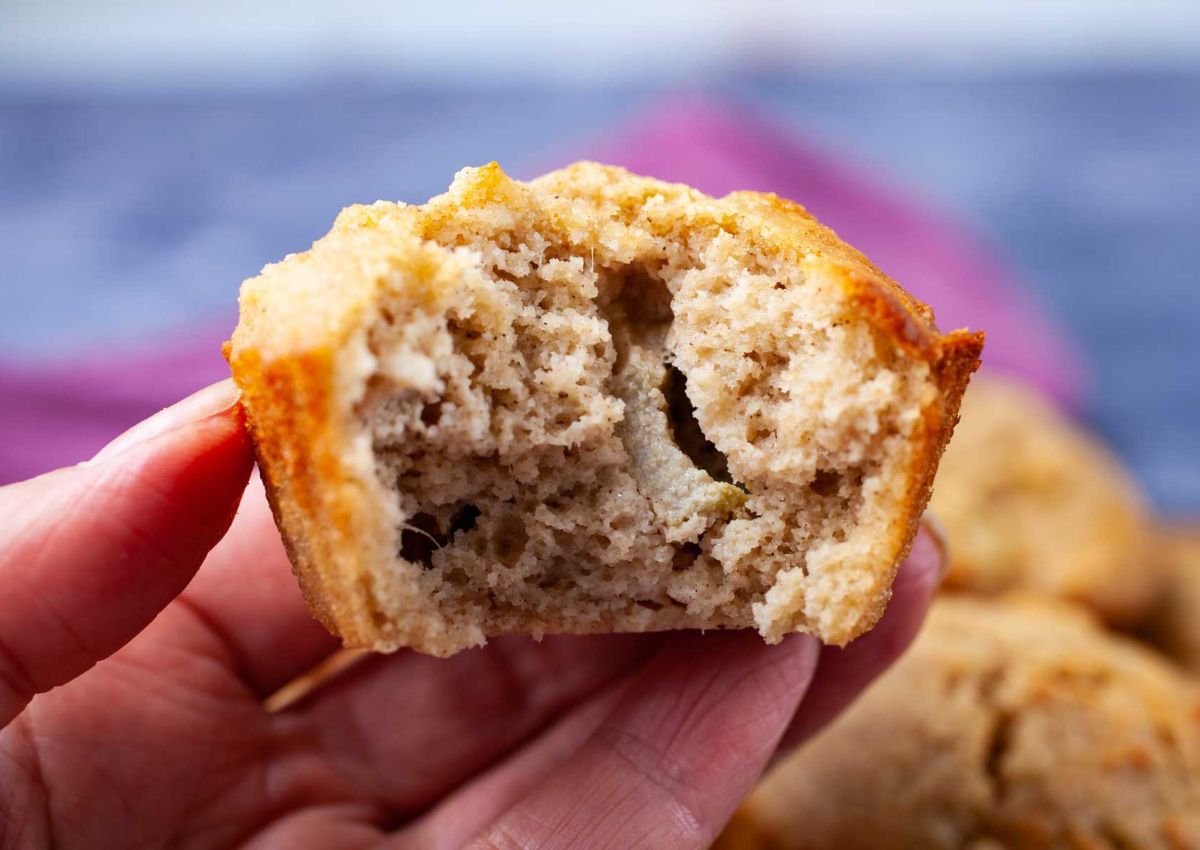 Rhubarb muffin with a bite missing held in woman's hand.