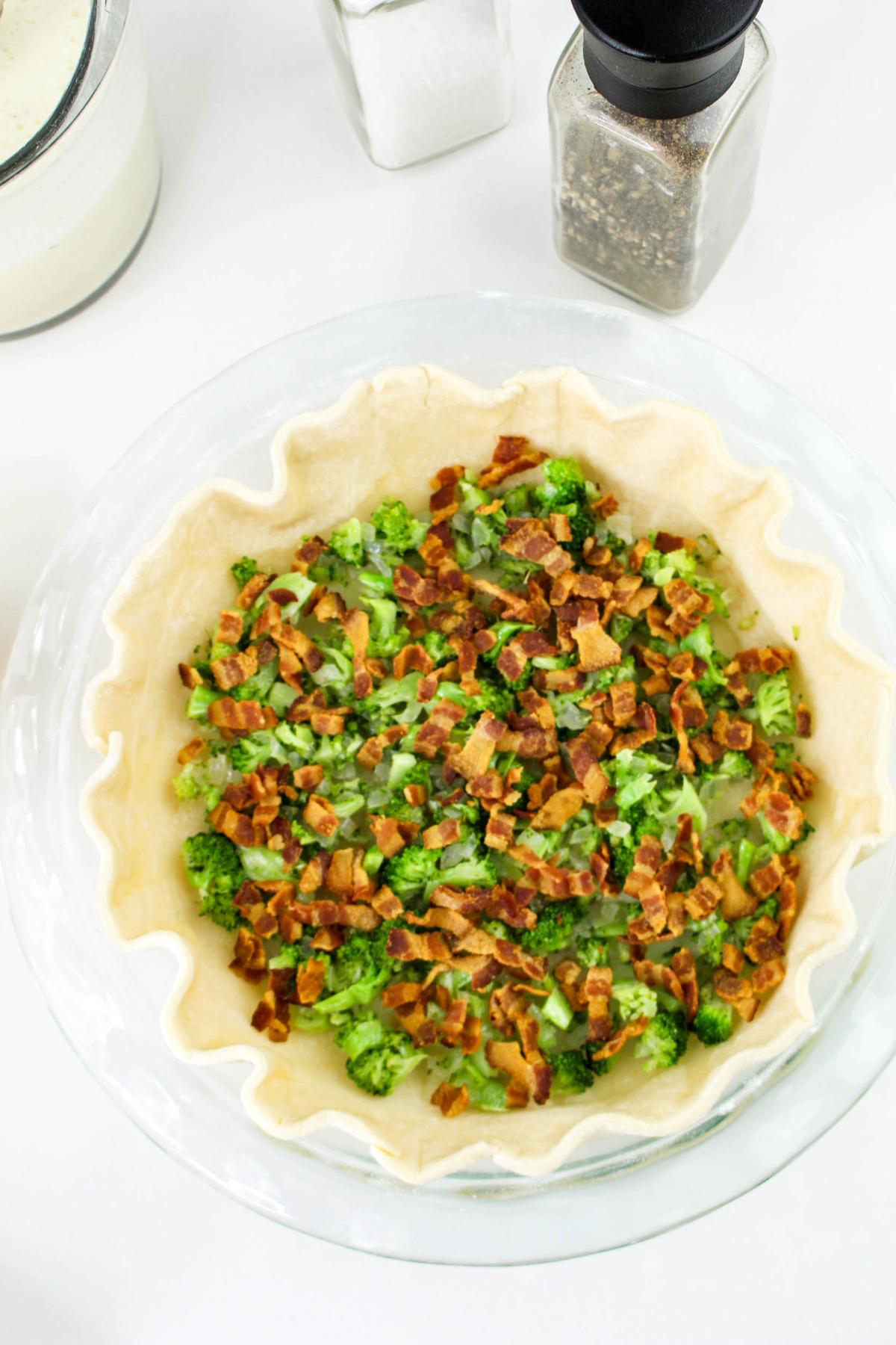 Chopped broccoli and cooked bacon in a pie crust before adding quiche filling.
