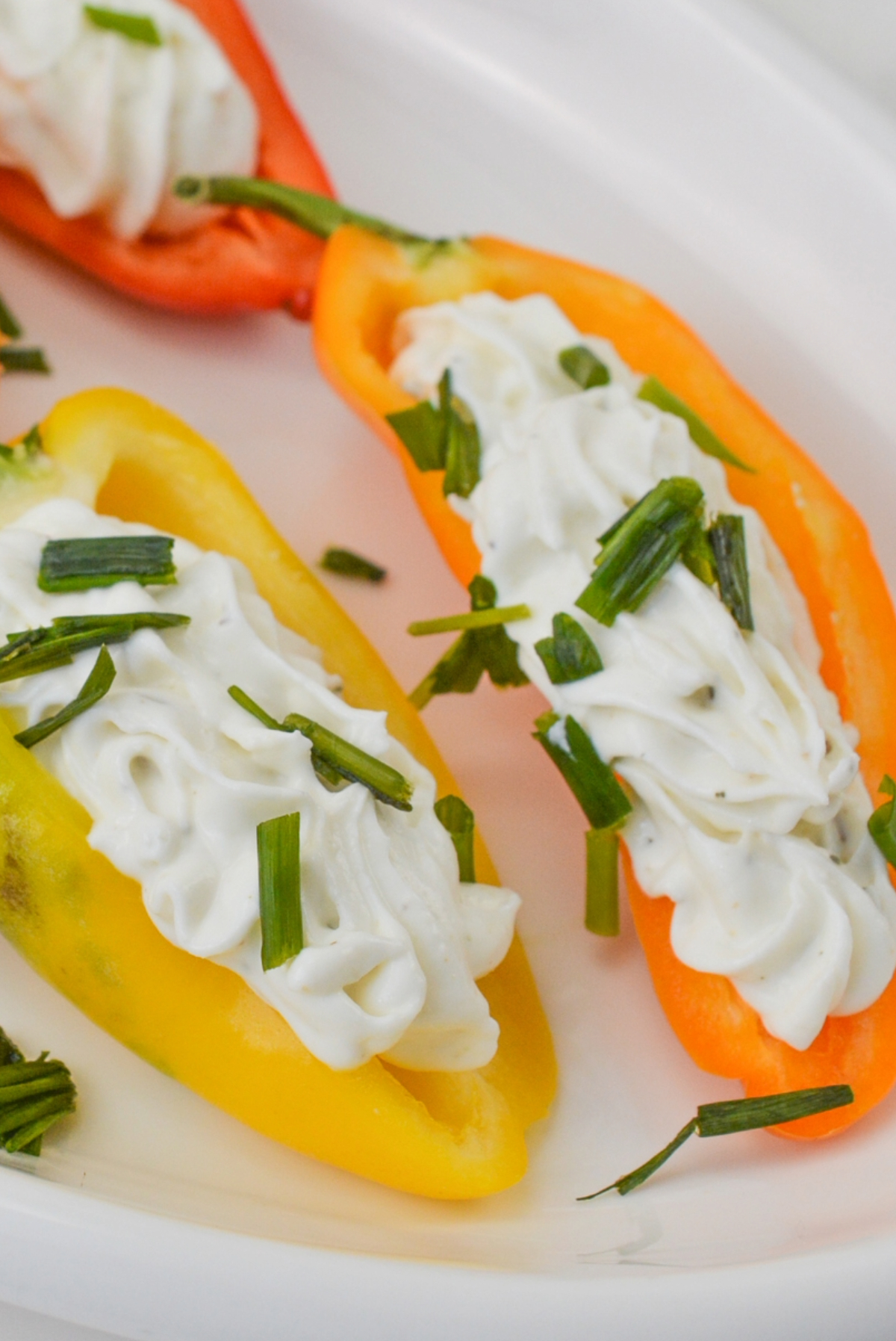 Stuffed mini peppers topped with chopped chives.