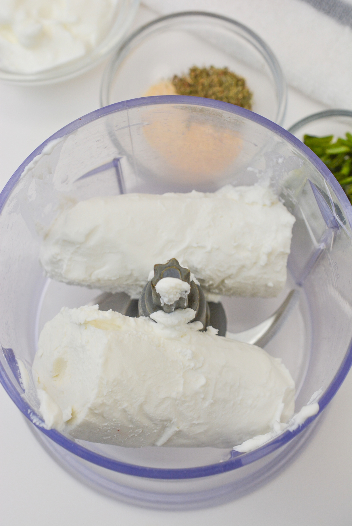 Fresh goat cheese placed in a food processor before blending.