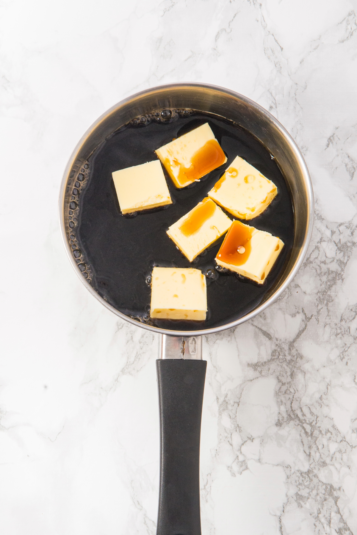 Guinness beer and butter melting in a saucepan.