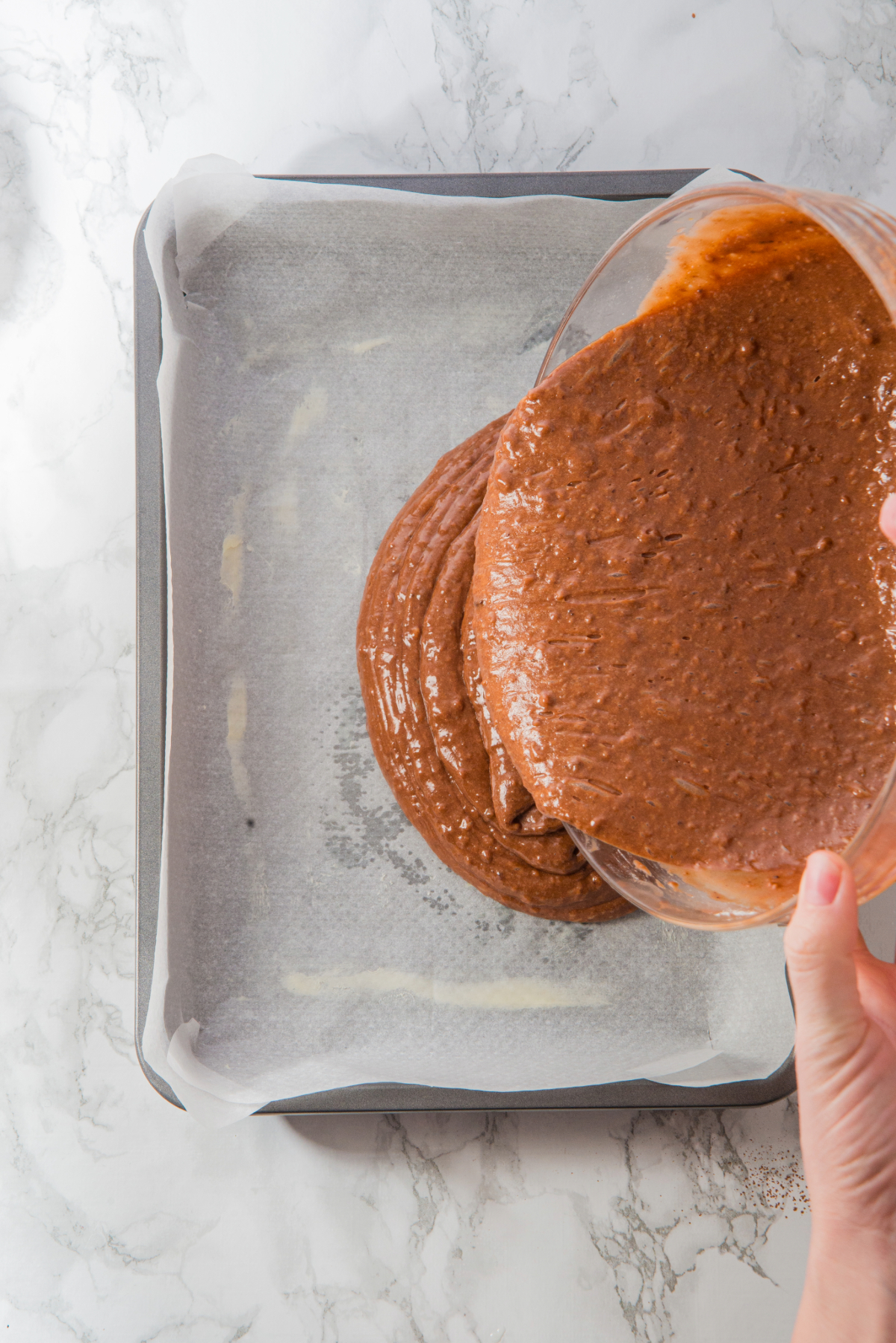 Guinness cake batter is poured into a prepared baking pan before placing it in the oven.