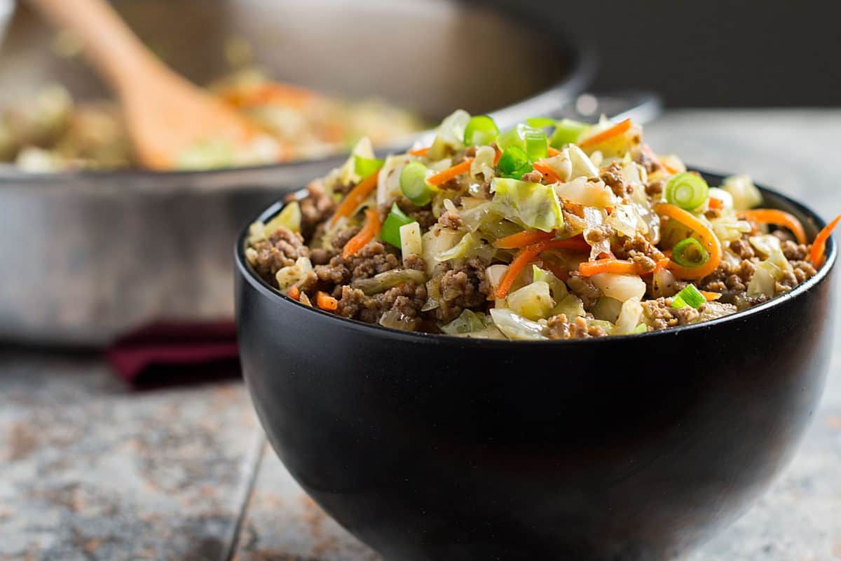 Dark colored bowl filled with egg roll in a bowl.
