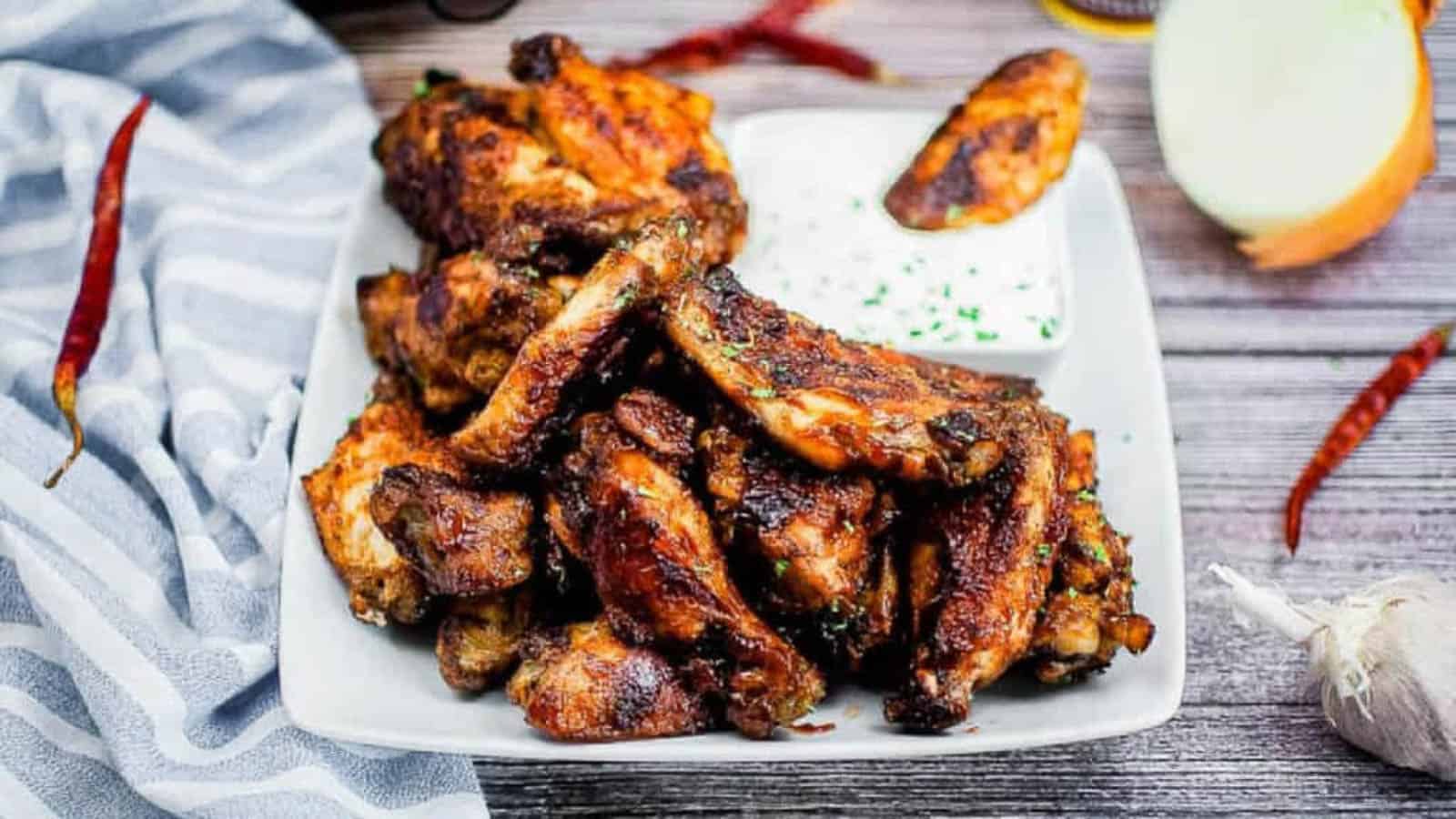 BBQ Wings on a white plate with dip.