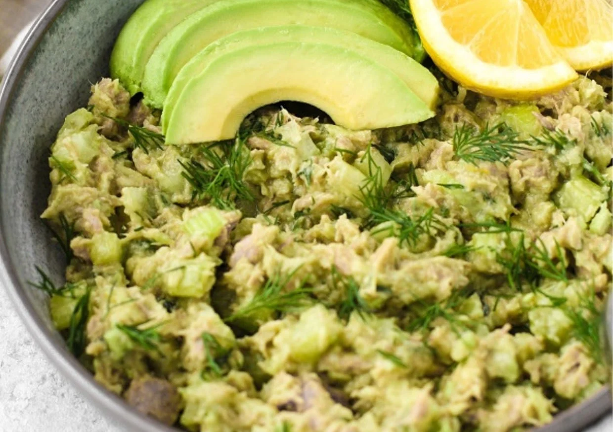 Bowl of Avocado Tuna Salad topped with avocado slices and lemon slices.