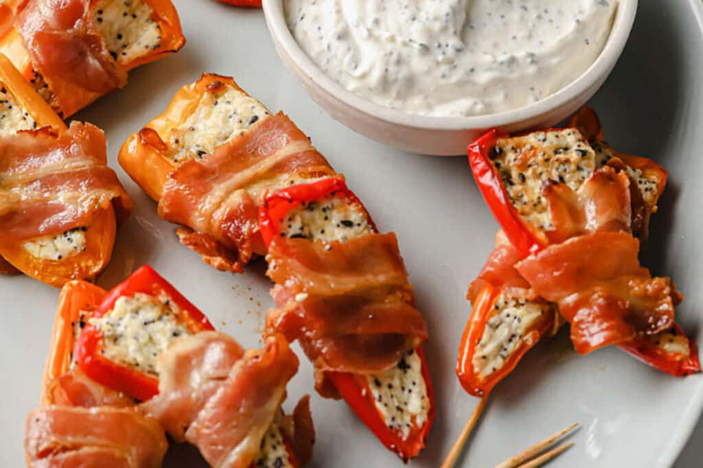 A plate of bacon wrapped mini peppers.