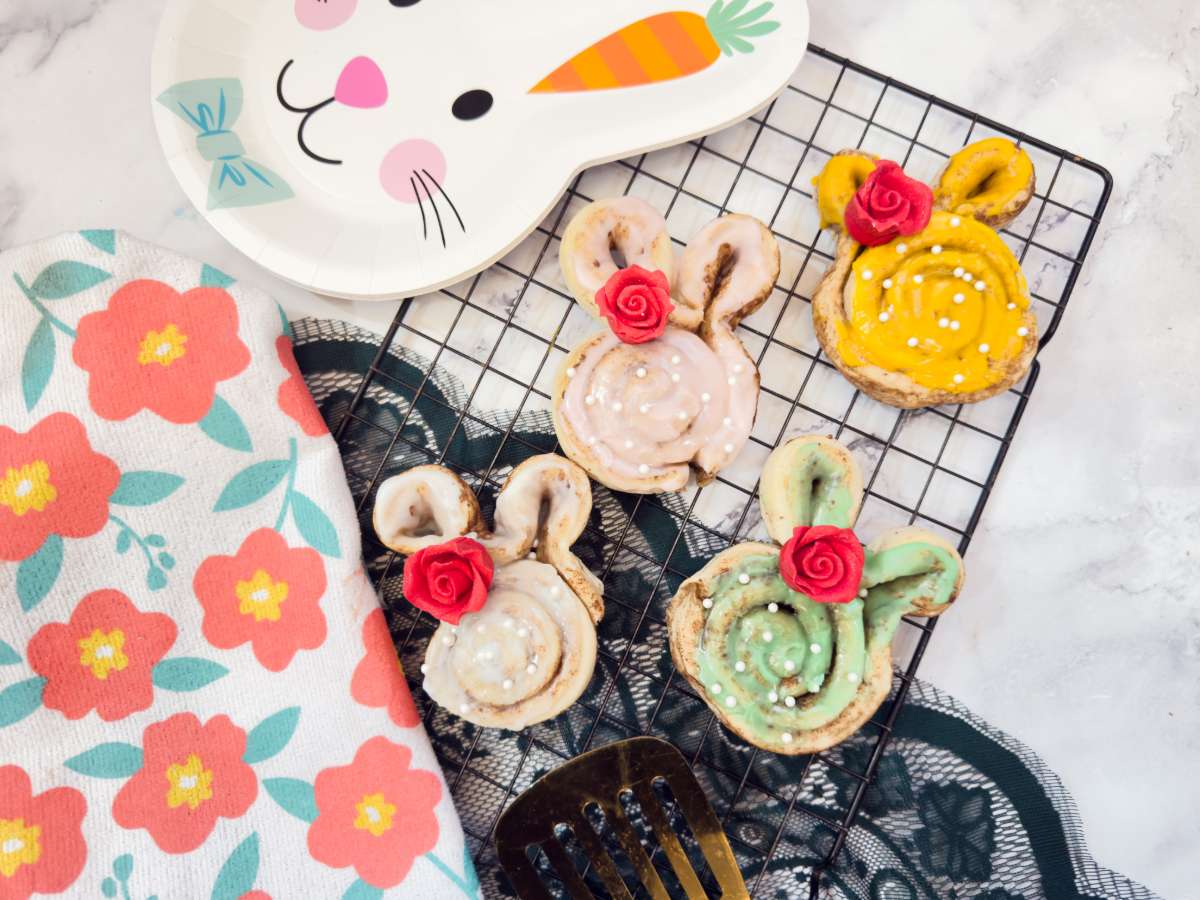 Cinnamon rolls shaped like bunnies on a cooling rack.