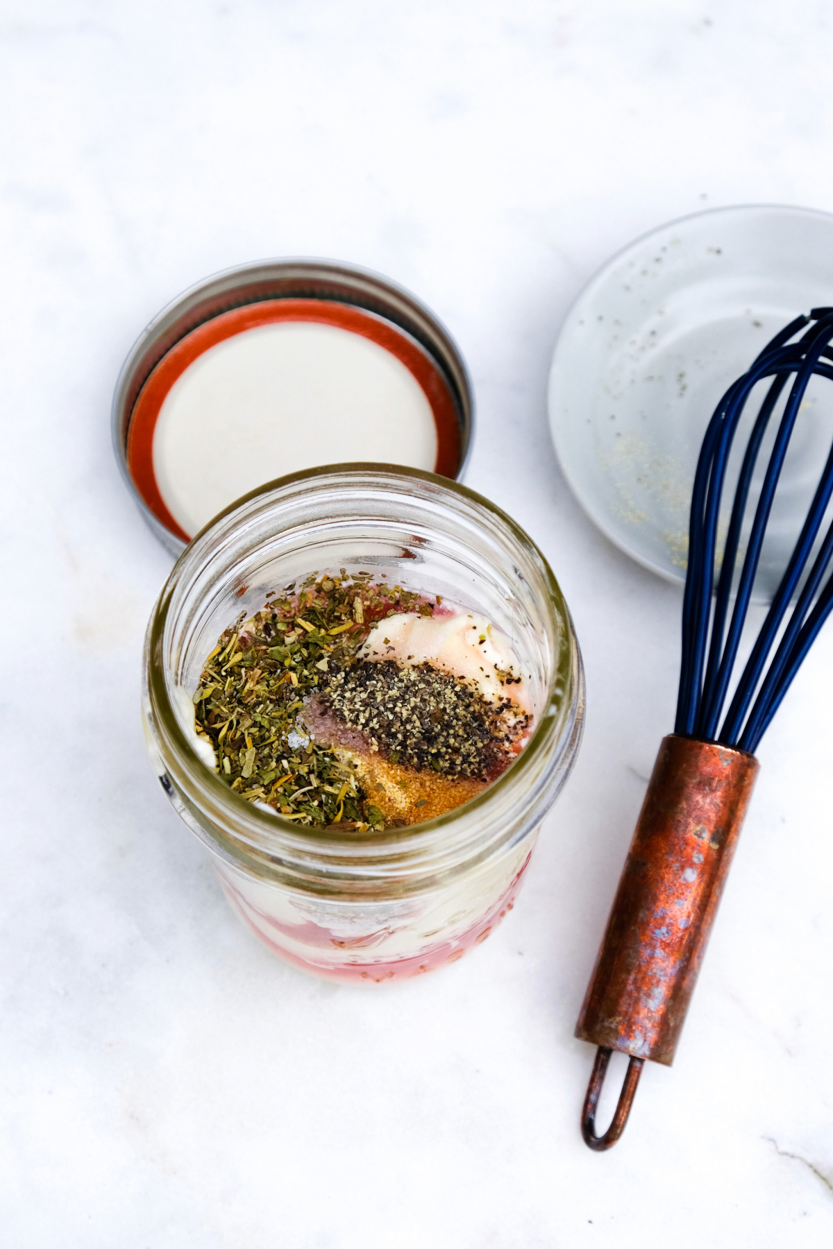 Salad dressing ingredients in a mason jar before mixing.