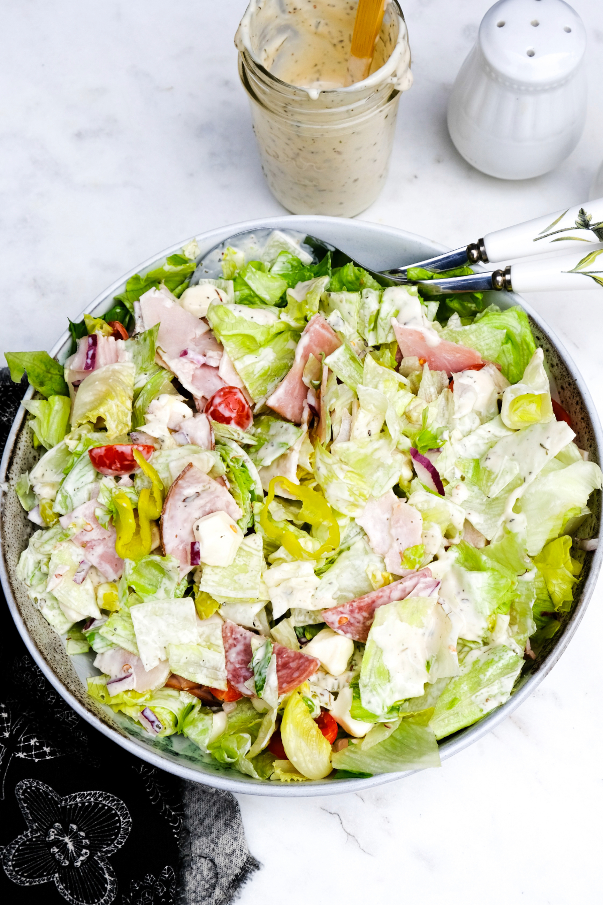 Salad in a bowl with chopped Italian meats and a creamy dressing ready to enjoy.