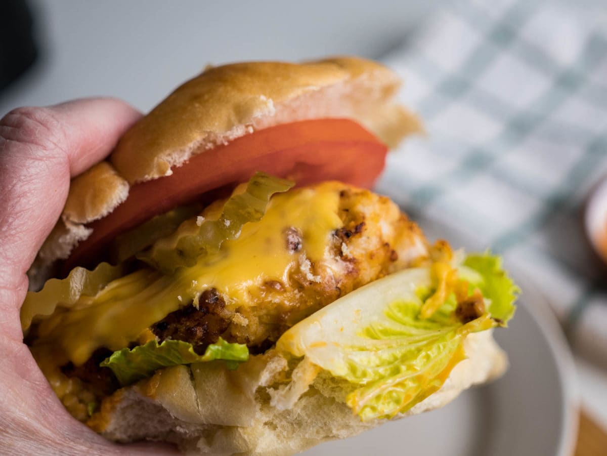 Chicken sandwich held in a woman's hand.