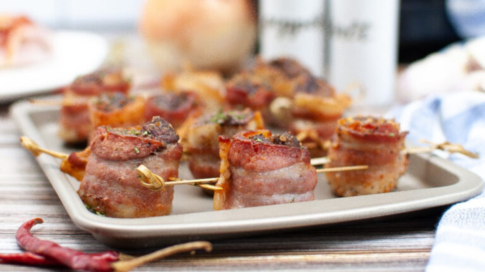 A baking sheet with steak covered bacon.