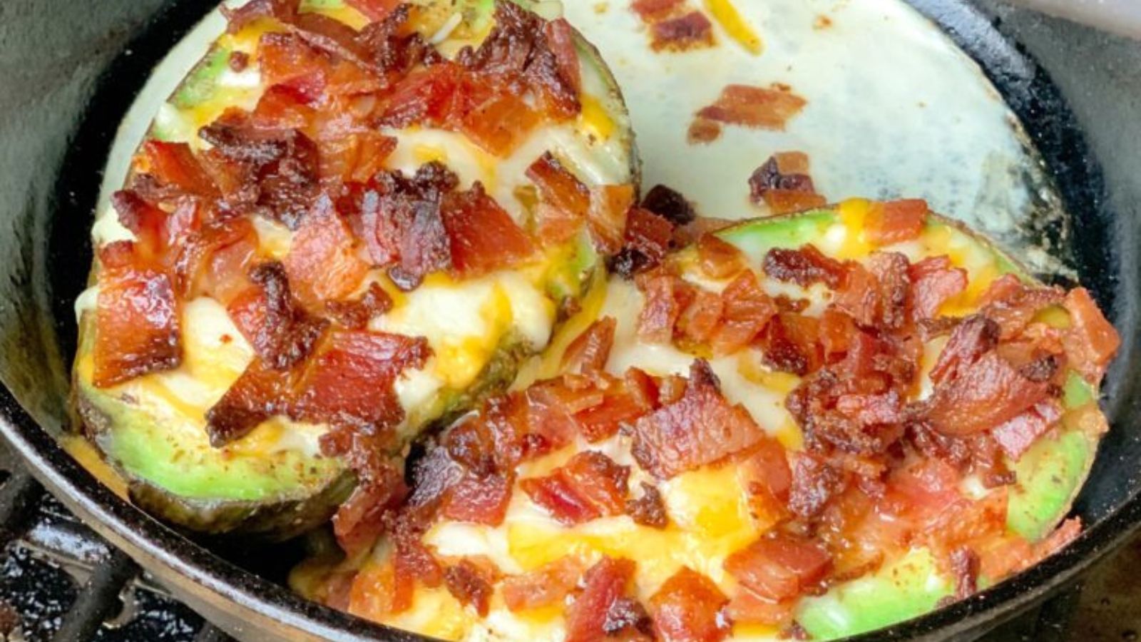 Avocado stuffed with eggs and bacon in a cast iron skillet. 