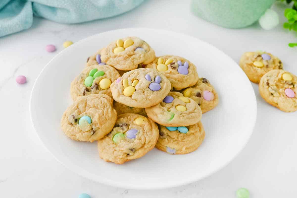 M&M cookies made with pastel candies on a white plate.