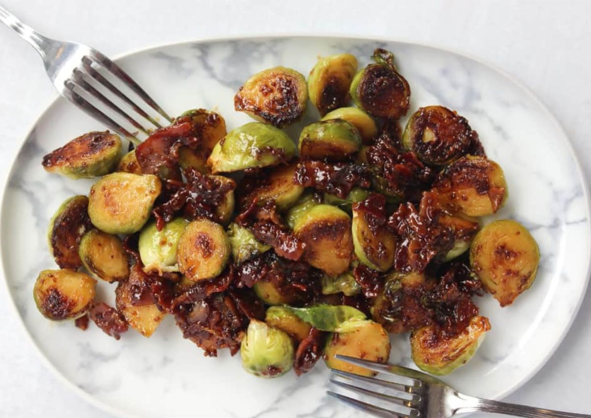 Honey mustard brussels sprouts on a marble serving platter. 