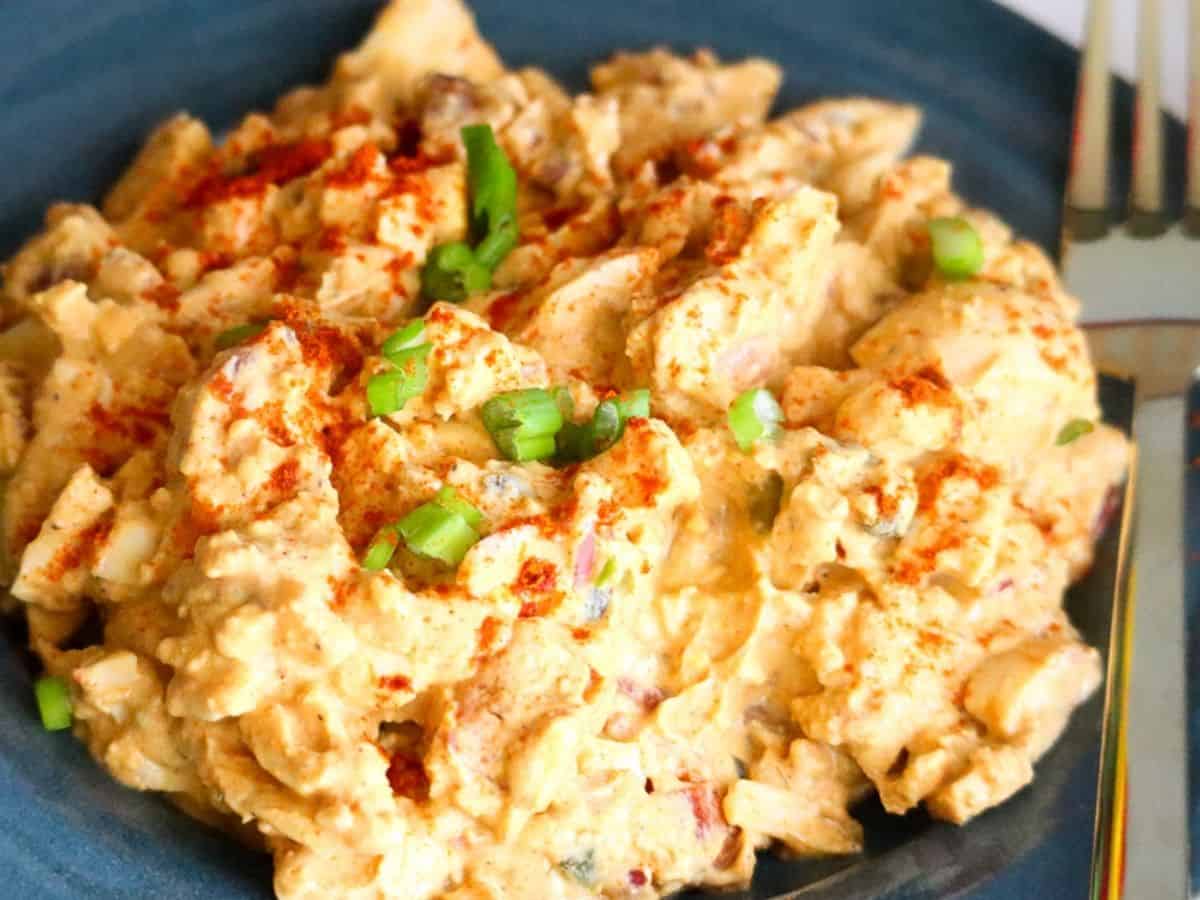 Keto deviled egg salad on a dark blue plate.