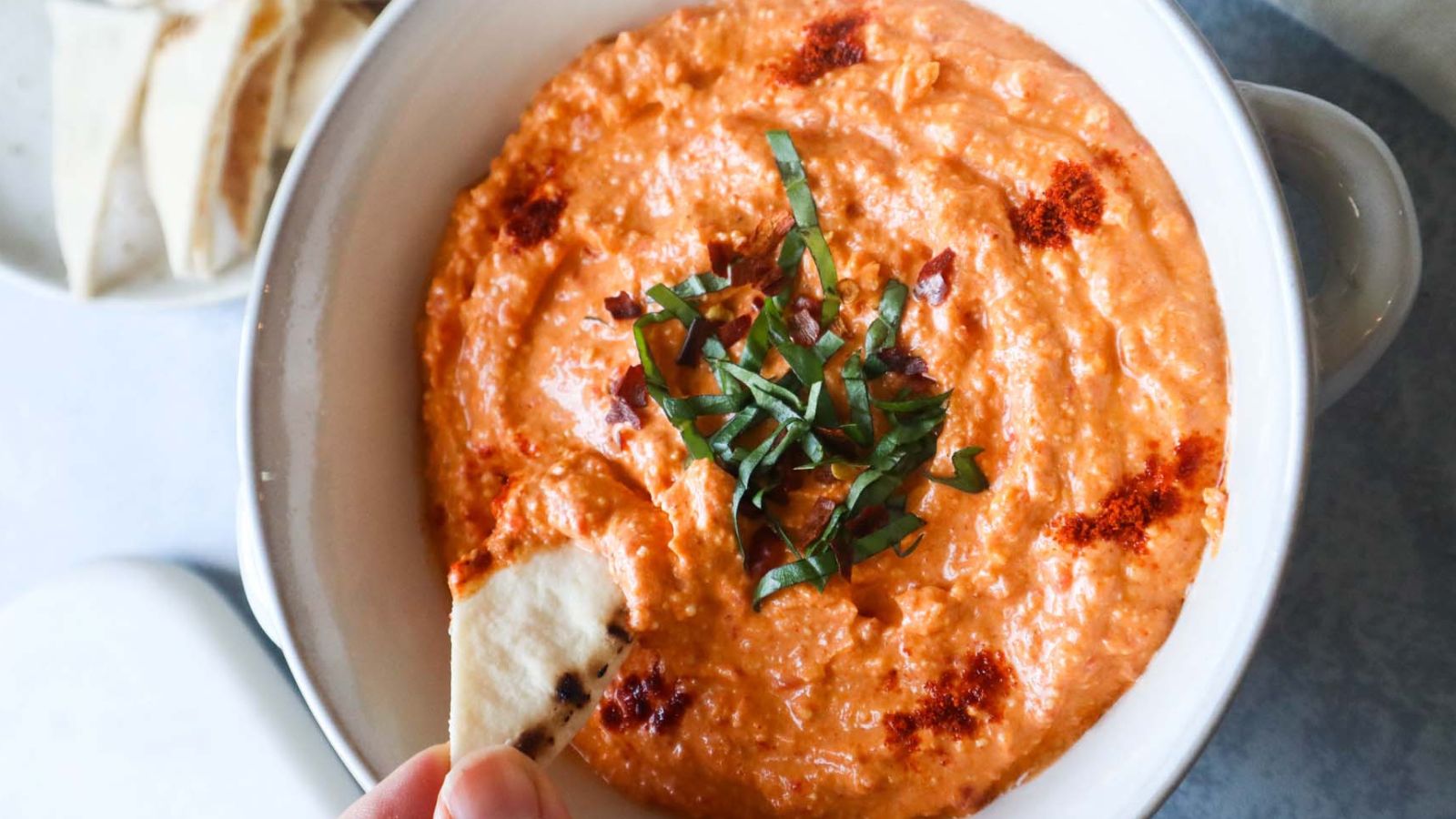 Bowl of paprika dip on a counter.
