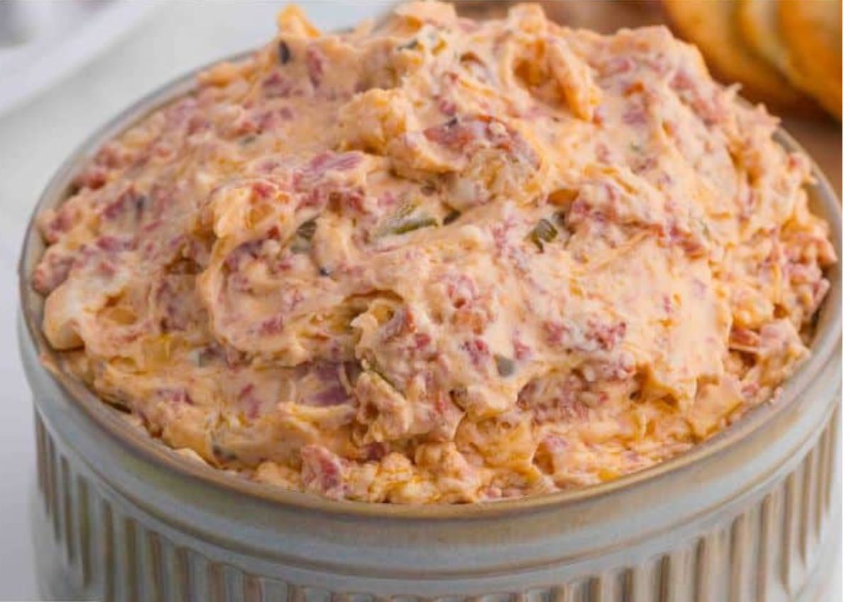 A ceramic bowl filled with a creamy and warm reuben dip. 