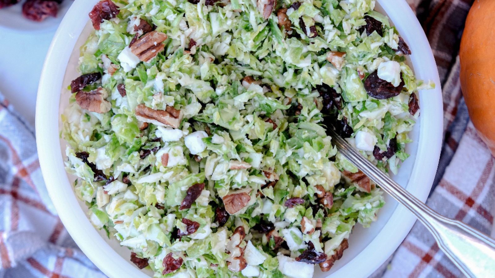 White bowl filled with shaved brussels sprouts salad. 