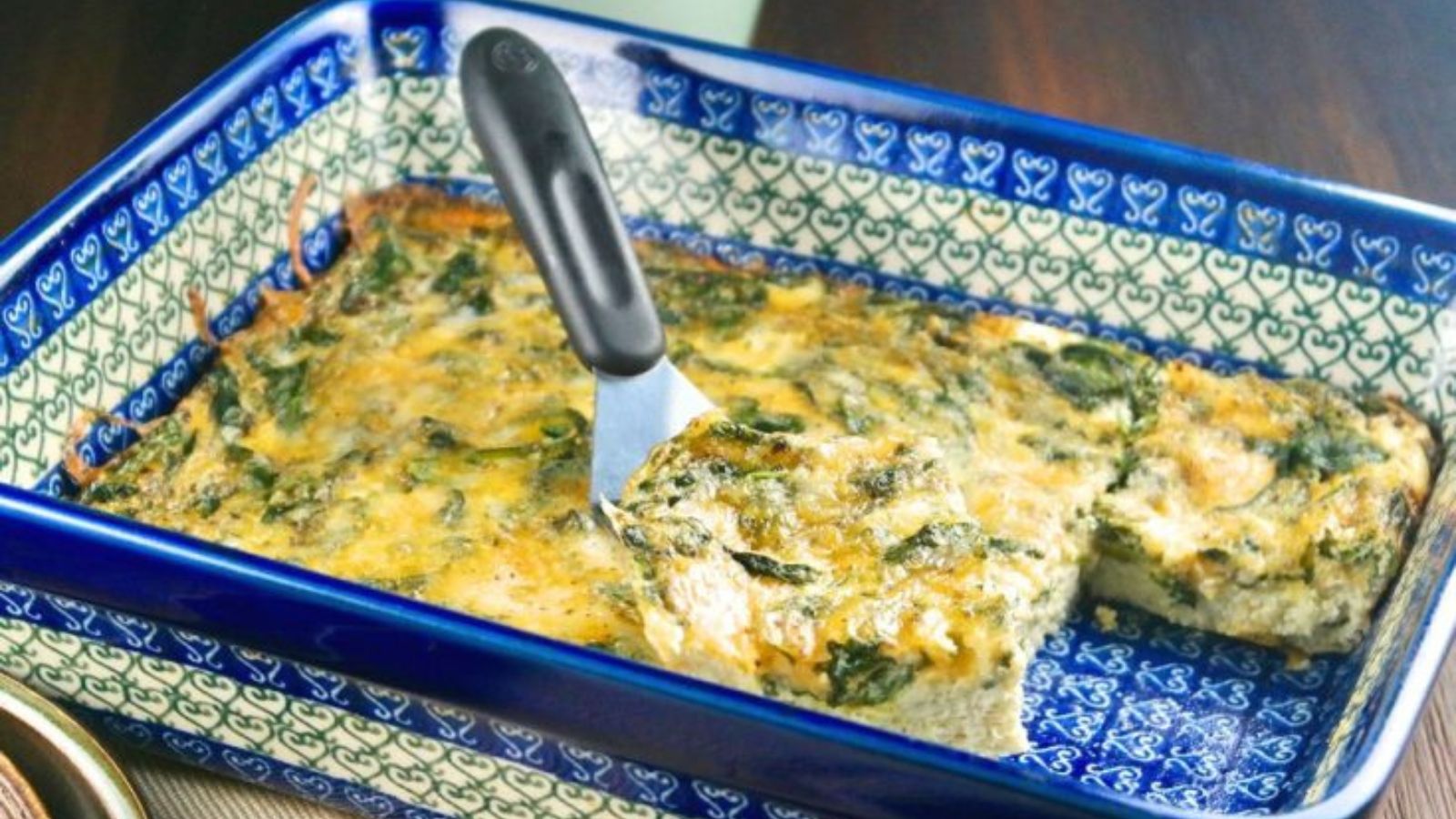 Slice of spinach egg bake being removed from the baking dish with a spaulta. 