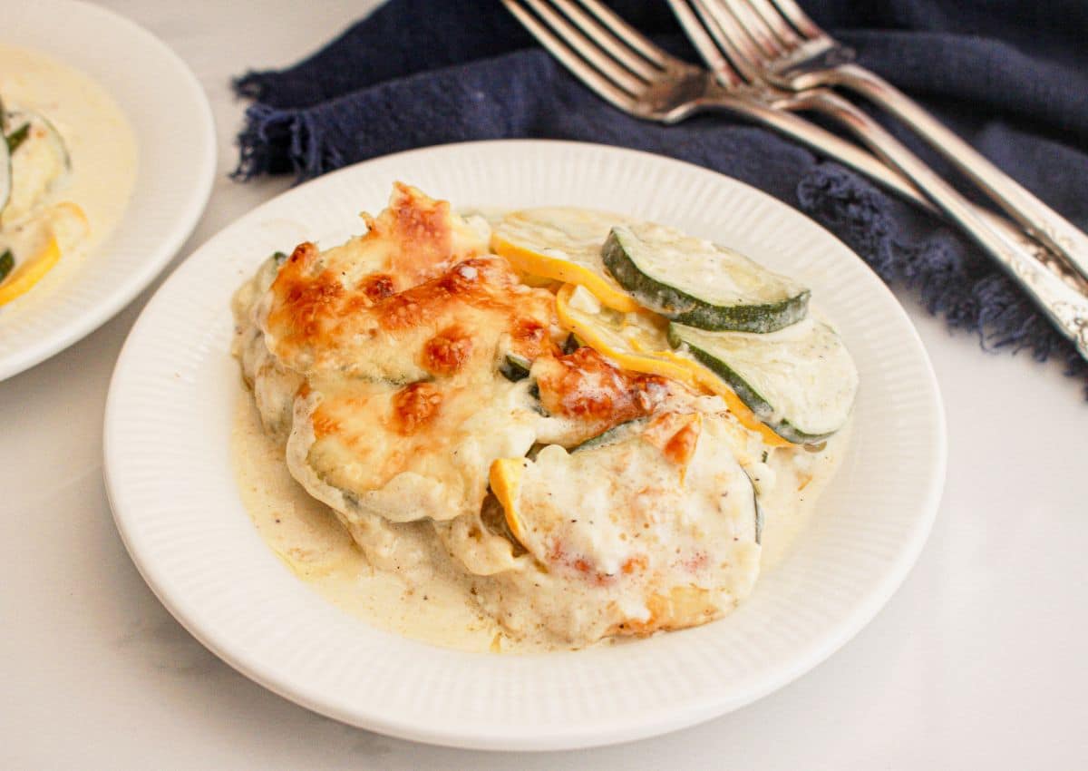 Serivng of zucchini and squash au gratin on a plate.