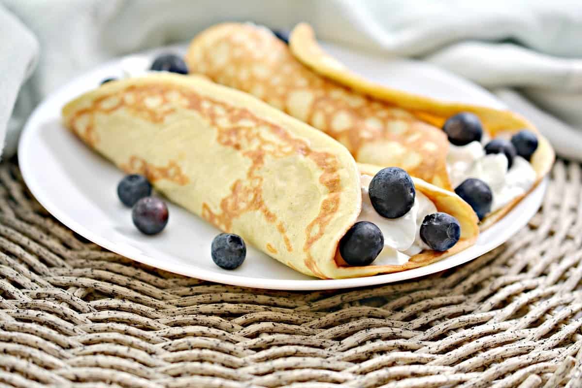 Two keto crepes filled with cream and blueberries.