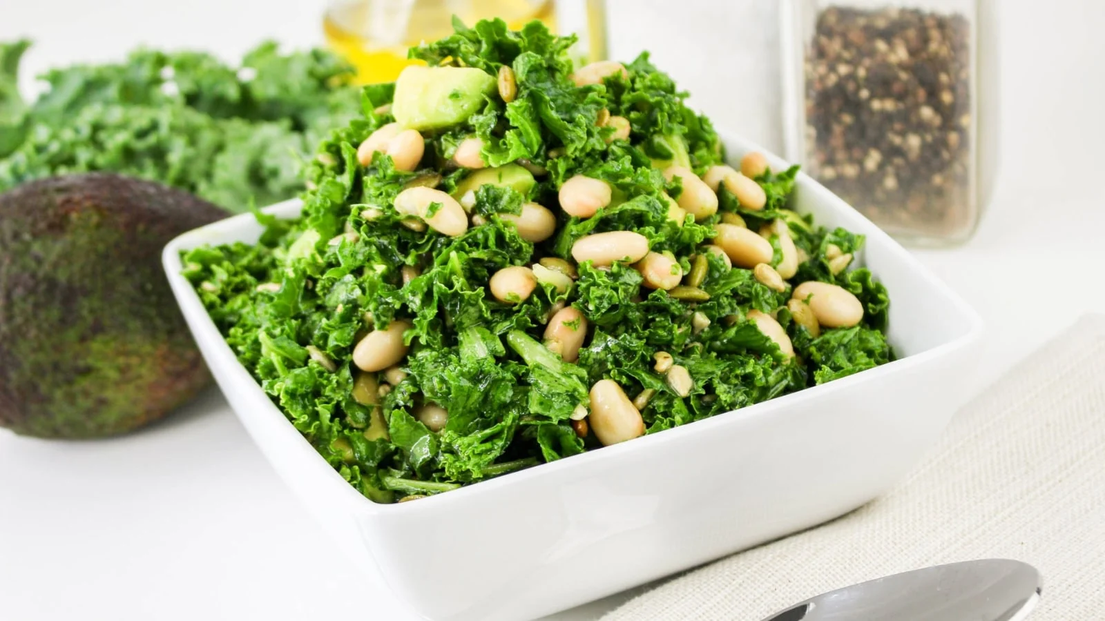 Kale and white bean salad in a white bowl.