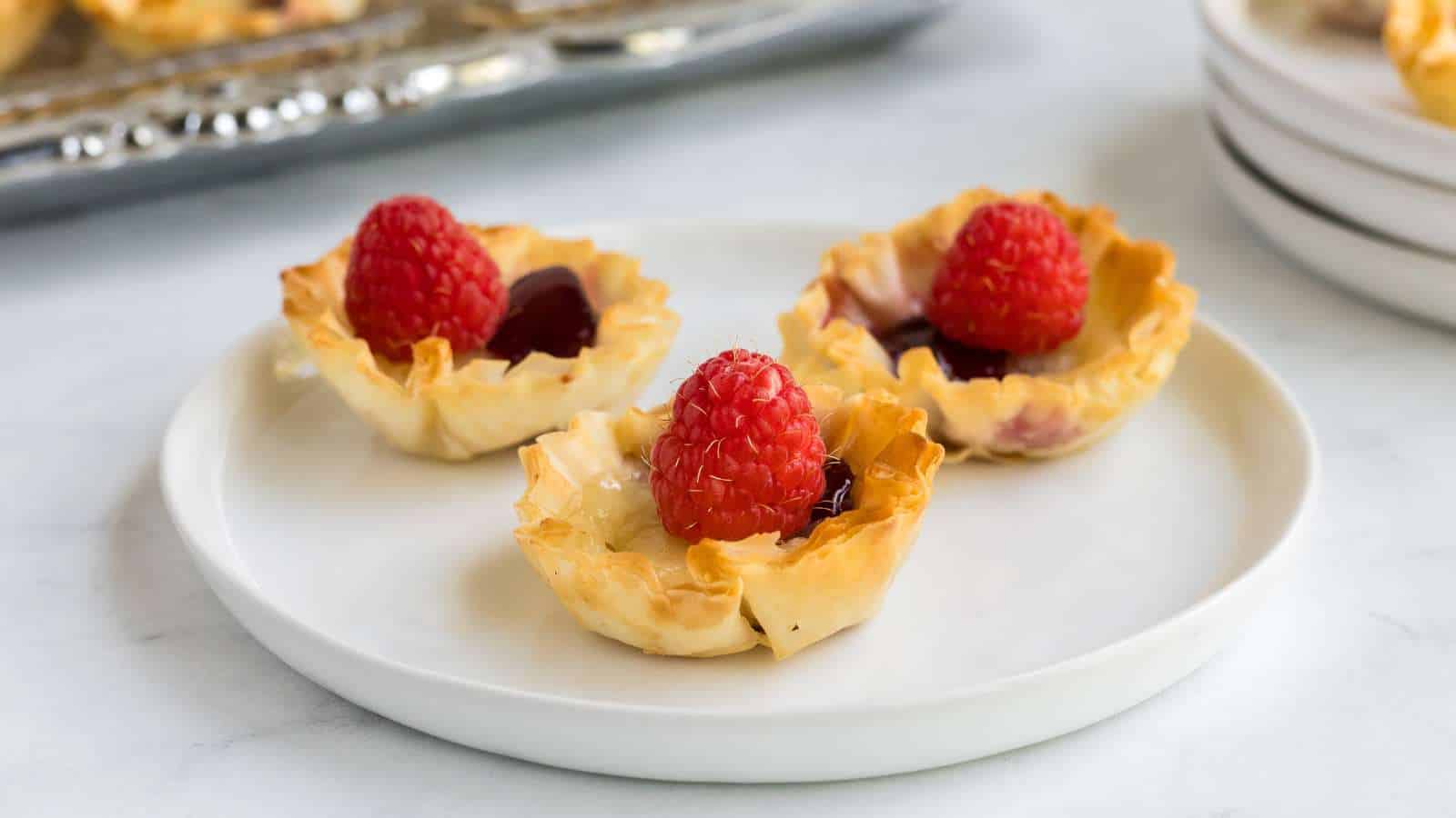Raspberry brie bits on a small plate.