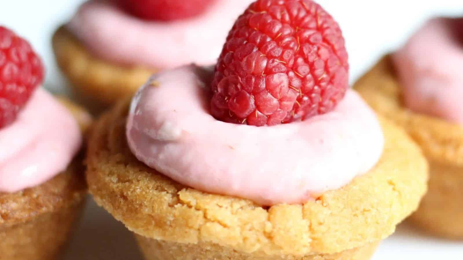Raspberry cheesecake cookie cups on a counter.