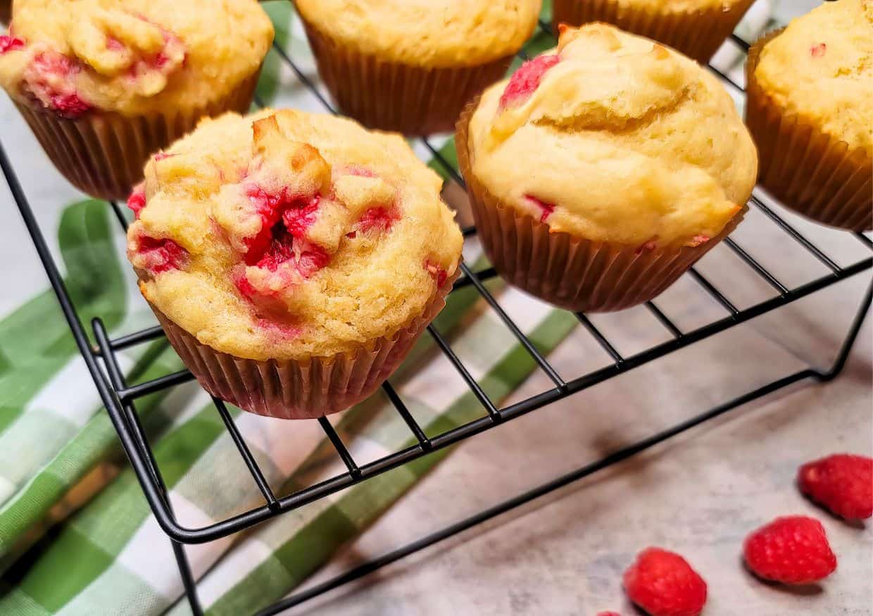 Raspberry muffins on a wire cooling rack.
