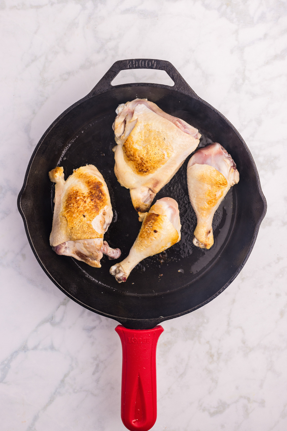 Browning chicken in a skillet.