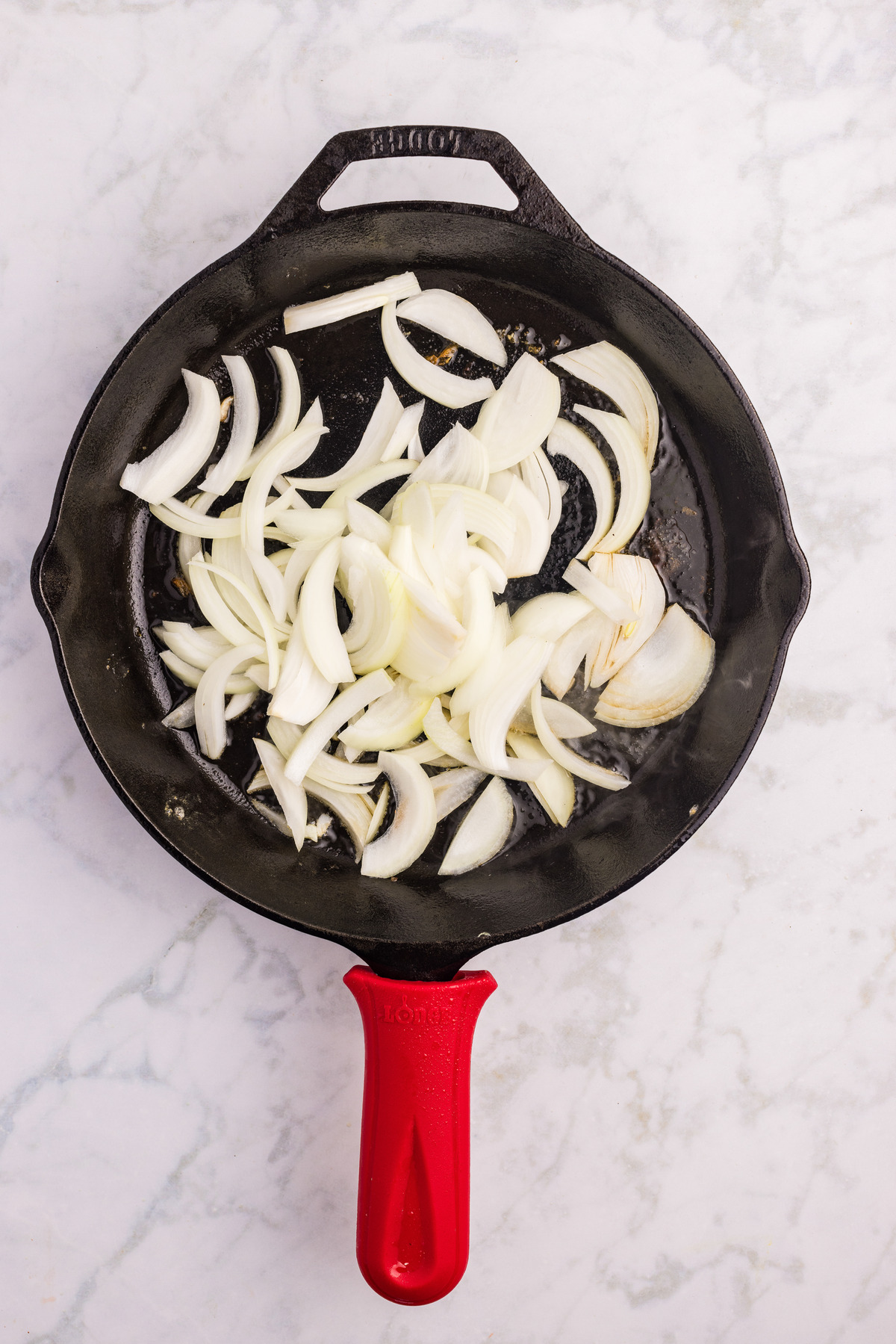 Sautéing sliced onion in a skillet.