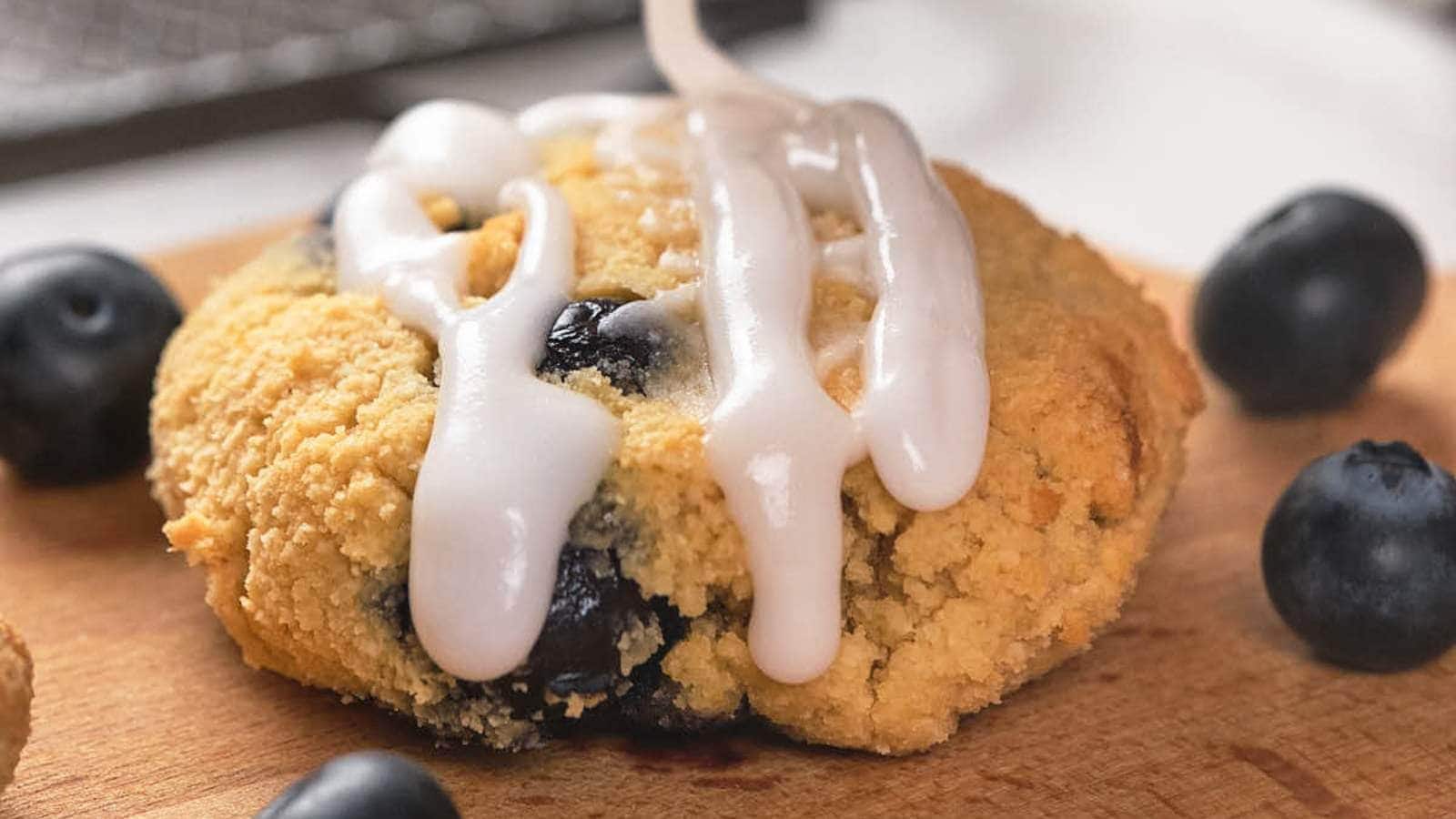 Keto blueberry scone on a wooden cutting board.