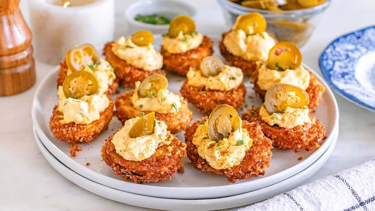 Deep fried deviled eggs on a white plate.