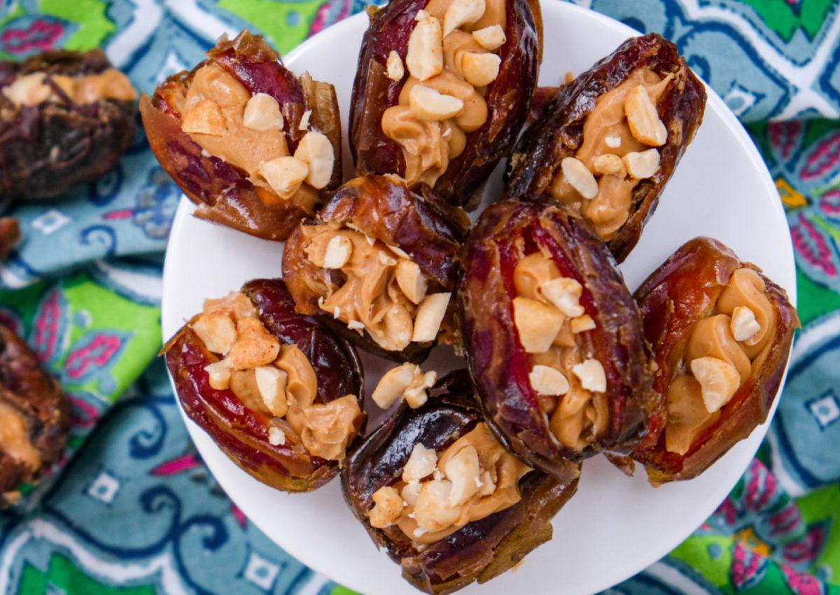 Peanut butter stuffed dates on a white plate.