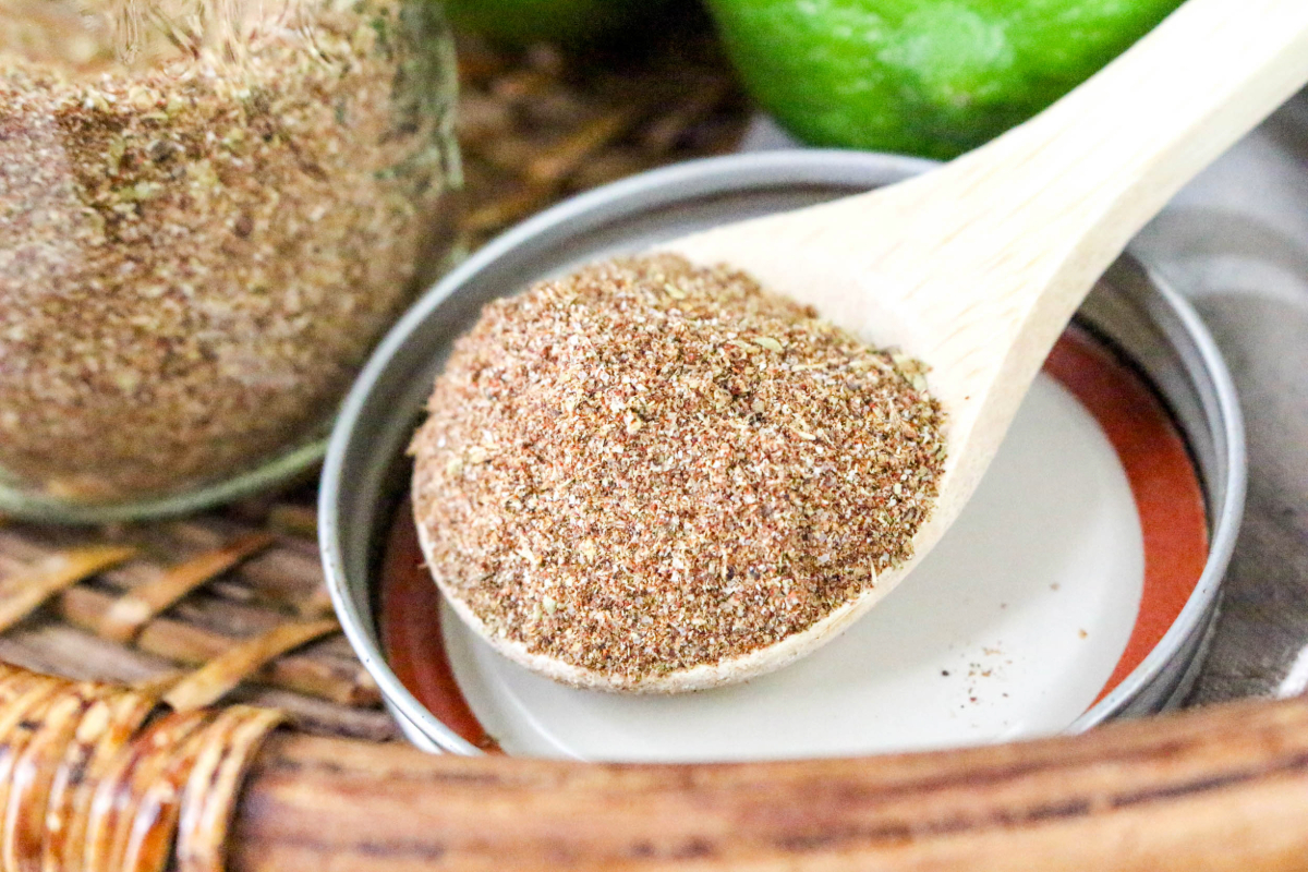 A small wooden spoon full of carne asada seasoning mix.