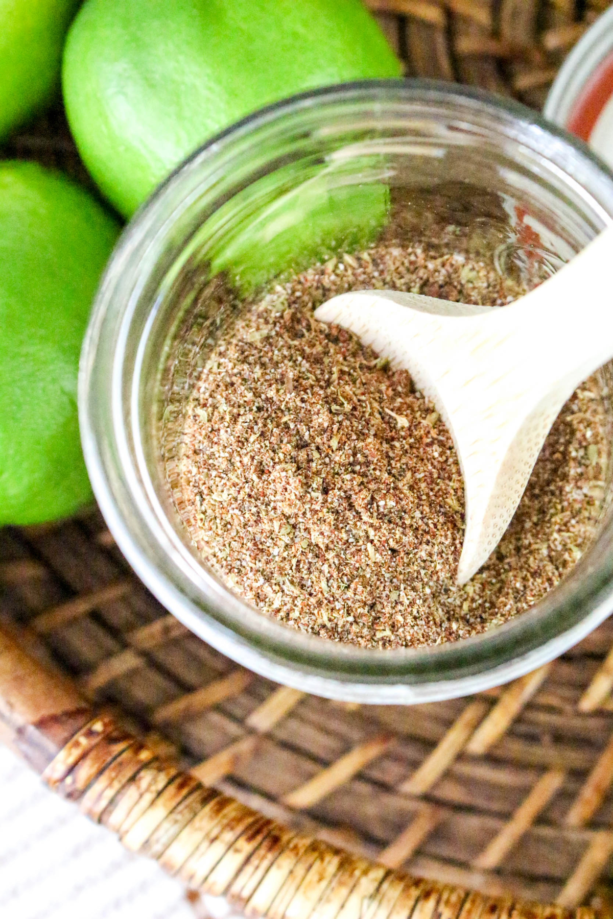 Overhead view of spices in a mason jar sitting in a brown wicker basket.