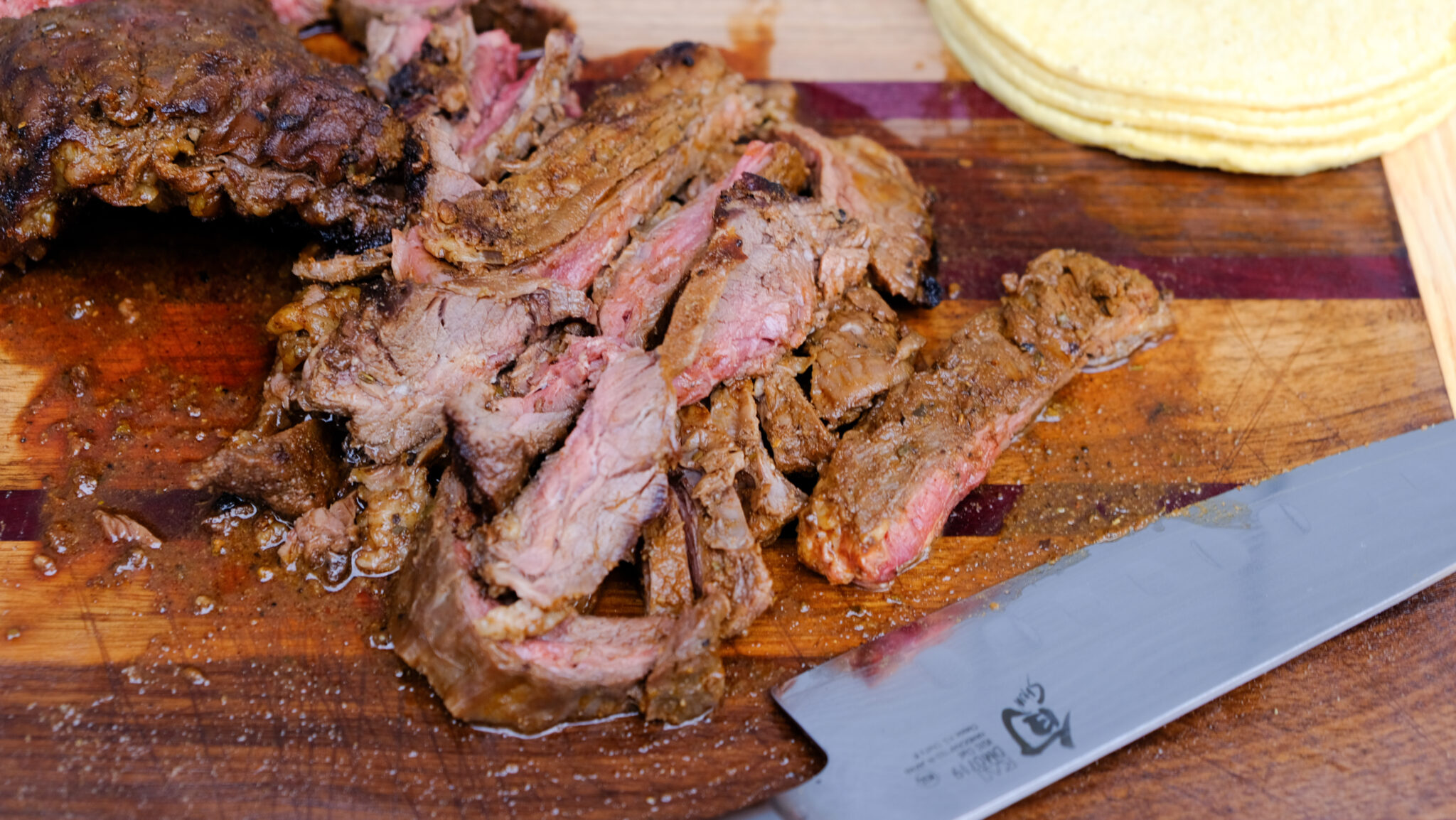Sliced skirt steak on a cutting board.