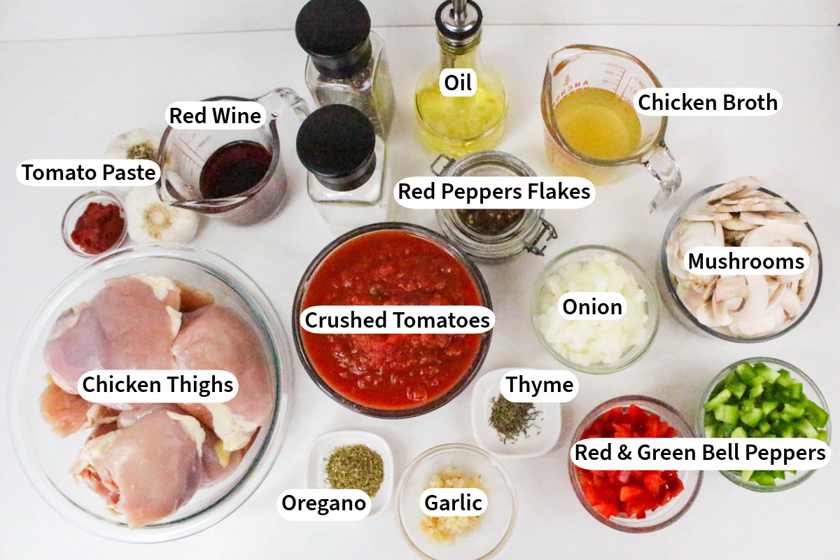 Overhead view of the ingredients to make chicken cacciatori in a Dutch oven. 