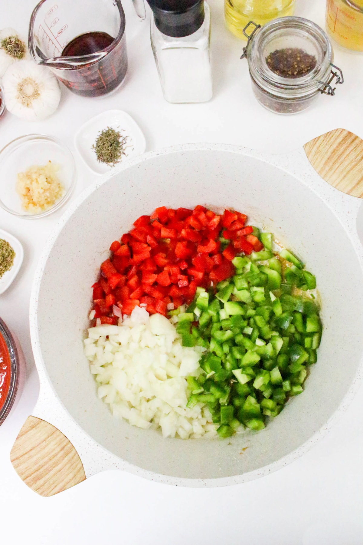 Diced onion, green and red bell peppers in a Dutch oven before sautéing.